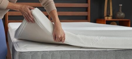 Mulher posicionando um pillow top de espuma sobre um colchão