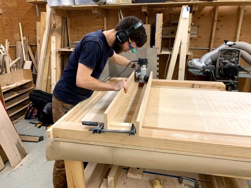 Marceneiro cortando madeira para a fabricação de uma cama sob medida