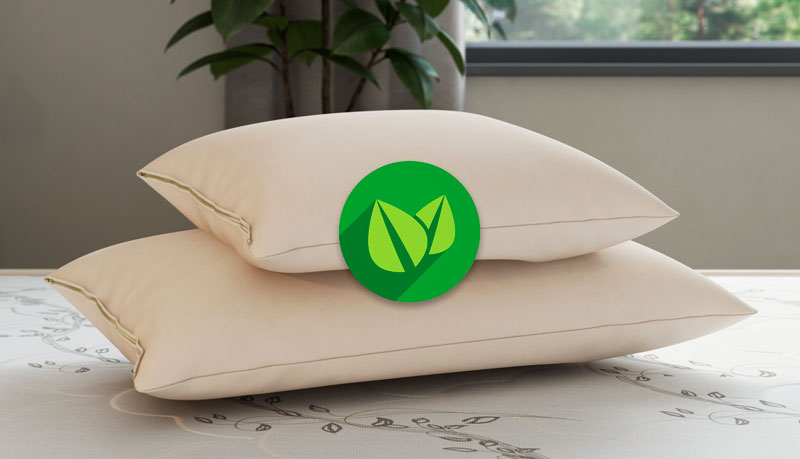 Dois travesseiros Látex sobre uma cama com um símbolo ecologicamente correto