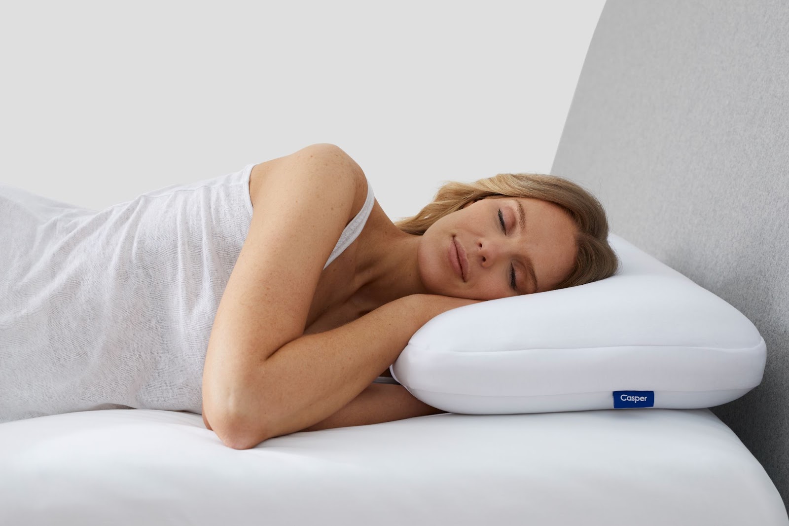 Mulher dormindo sobre travesseiro branco.